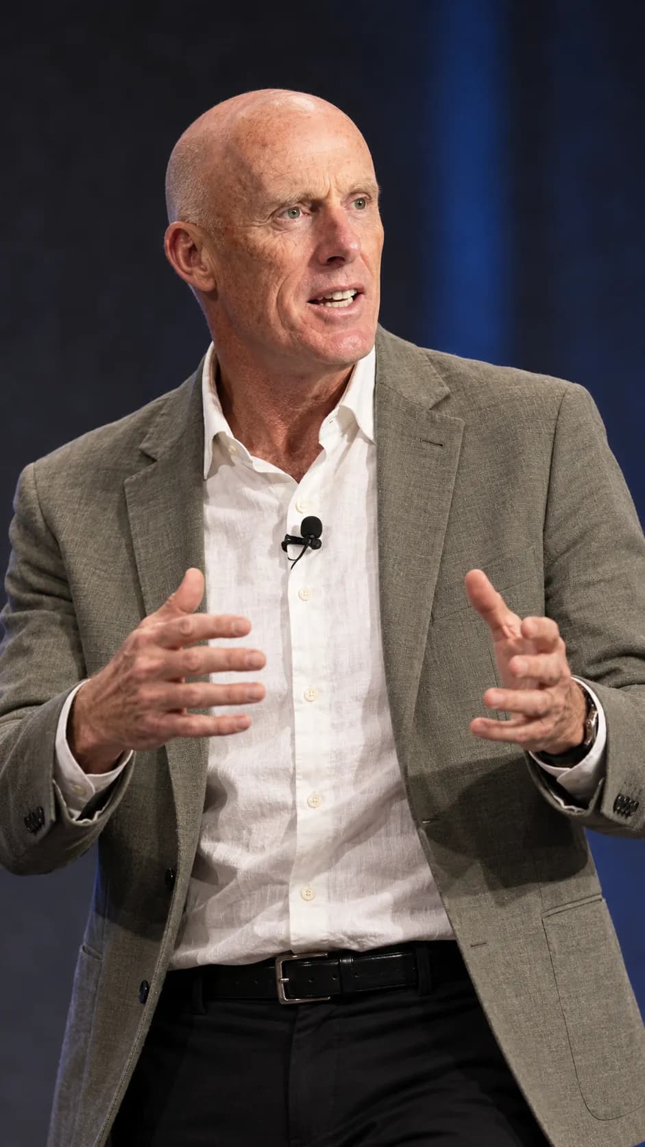 Mark McKeon gesturing as he explains a point on stage during The 4 Hows of High Performance Teams