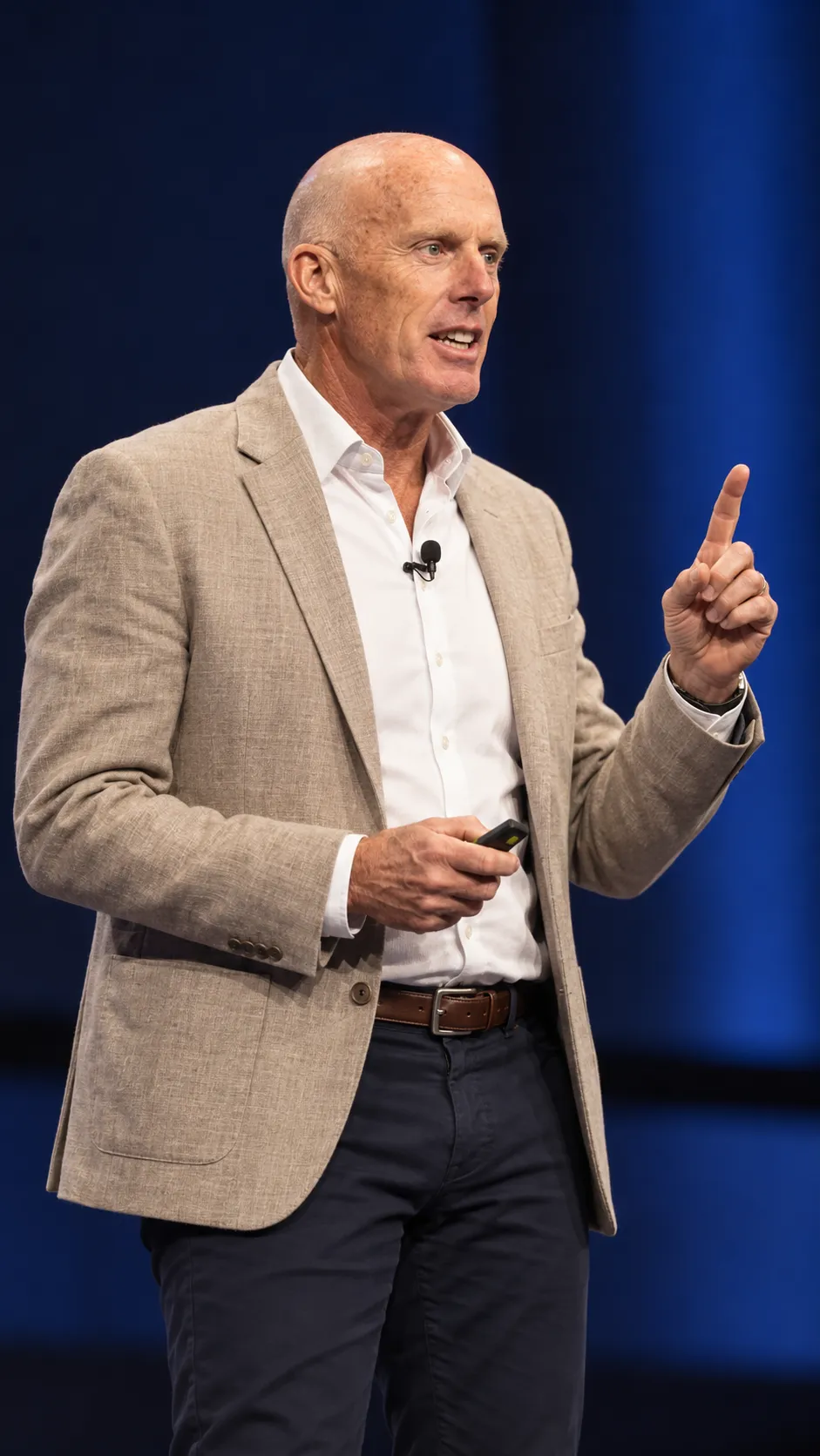 Mark McKeon pointing upward to make a point on stage during Embracing Change